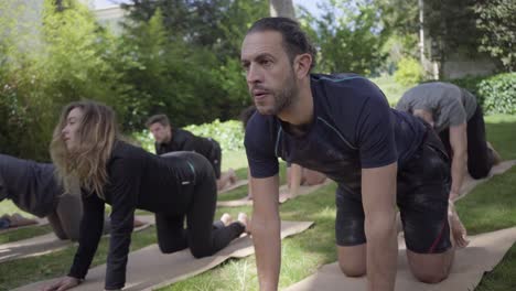 Gente-Arrodillada-Y-Practicando-Yoga-En-El-Parque